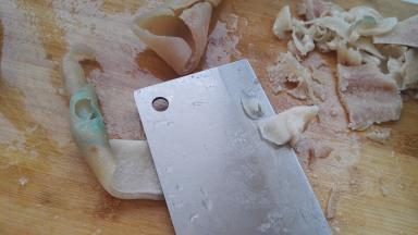 猪皮带油面朝上，把刀倾斜，逐片把猪皮上的猪油刮干净（猪油可以炼油炒菜，油渣可以包包子，当然，如果不喜欢就扔了吧）。把猪皮再清洗下，防止沾上猪毛猪油。