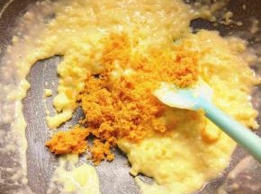 然后成糊状的时候加入四个压碎的咸蛋黄慢慢炒到报团即可