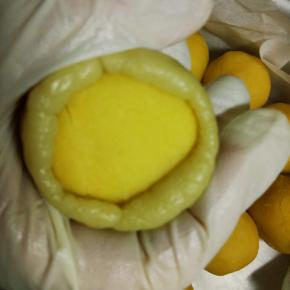 把冷藏好的饼皮分为30克一个的圆球，然后压扁包入冷冻好的奶黄流心馅中馅