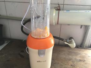 最后做慕斯镜面，将芒果切成颗粒，放入榨汁机中，倒入纯牛奶和凉开水，榨成汁