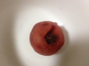 装巧克力酱裱花袋剪小口 把巧克力酱注入刚才做好的樱桃馅里 尽量注到洞里 轻轻磕一磕 让巧克力酱沉下去