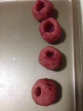 月饼馅用筷子戳洞  这一步一定要小心 底稍微厚点 用筷子头把洞扩大 比4克巧克力酱的量更大一些 保证完整不裂 慢慢把口收小一点