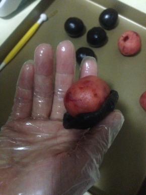 那一片压扁的月饼皮包住处理好的月饼馅 包平整 再用另一片盖在另一半馅上 对着把接缝推平