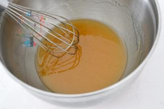 使用手动打蛋器混合搅拌至花生油乳化发白和糖浆融为一体