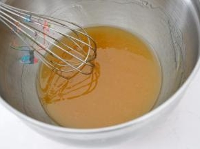 使用手动打蛋器混合搅拌至花生油乳化发白和糖浆融为一体