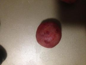 把口收紧 不要有裂缝 如果实在包不上 可以再取一点樱桃馅捏扁 扣在洞口抹平 千万不要有裂缝 要不然 下一步可能压模的时候 就露馅了 烘烤后会破