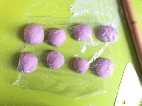 然后卷起面团，分成大约30g一个面团，面团可以大小不一，这样更能模仿大小不同的紫薯，分成8个面团，滚圆，盖上保鲜膜醒发15分钟