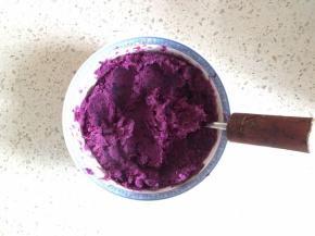 蒸熟的紫薯用大勺子碾成泥