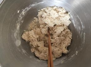 一边倒入清水一边用筷子搅拌，搅拌成棉絮状，盆内无干面粉