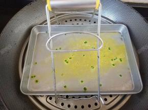 打开锅盖看到粉浆鼓出大气泡便是熟了，用夹子取出盘子