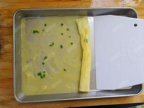 刮板从盘子一侧刮并卷起，一个肠粉就做好了