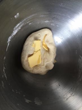 然后开始揉，揉到面团摸上去有点粘手但是不会粘下来面团，加入软化的黄油，继续揉