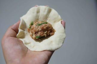 放入适量肉馅捏成包子得样子