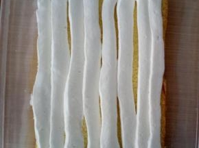 取出淡奶油，裱花袋剪个口，挤一层奶油在面包片上。