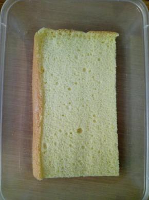 取一个小一些的蛋糕片，放在盒子底部。