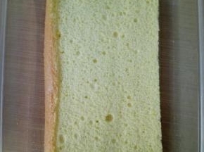 取一个小一些的蛋糕片，放在盒子底部。