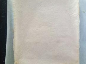 烤好的蛋糕体取出，在桌上轻震一下，倒扣在铺了油纸的烤网上，底下的油纸揭掉，再盖在蛋糕体上，以免蛋糕干掉。