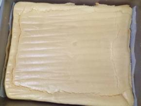 把蛋糕糊倒入铺了油纸的金盘中，刮板抹平表面，我用的是11寸深盘。送入预热好的烤箱中层，上火150度下火135度，烤25分钟左右。