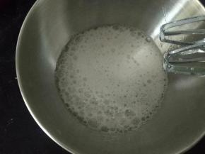 取出冷藏的蛋清，加几滴白醋，先用低速打到大粗泡状态，放入三分之一份糖，此时预热烤箱150度上下火10分钟。