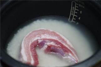 按平时煮饭的水量，加至在电饭煲里，再将洗好的五花肉放至在上面。
