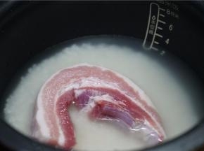 按平时煮饭的水量，加至在电饭煲里，再将洗好的五花肉放至在上面。