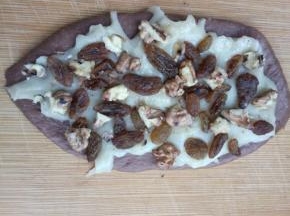 均匀放上葡萄干、核桃仁，用手轻压一下；