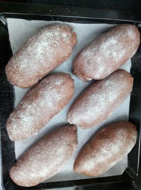 放烤箱内，进行二次发酵，烤箱内放一碗60度左右的热水，在烤箱中制造蒸汽，使面包表皮不至干硬，面包发酵到2倍大，取出，表面筛面粉；