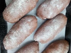 放烤箱内，进行二次发酵，烤箱内放一碗60度左右的热水，在烤箱中制造蒸汽，使面包表皮不至干硬，面包发酵到2倍大，取出，表面筛面粉；