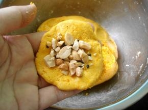 取一小块面团，压扁摊开放入适量花生芝麻