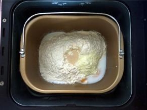 将黄油除外的食材按照先液体后固体的顺序放入面包机桶里，启动揉面程序揉面20分钟。