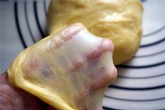 面包机揉面结束后，取出面团摔打10分钟左右便可以轻松拉出手套膜。