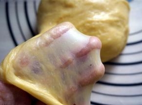 面包机揉面结束后，取出面团摔打10分钟左右便可以轻松拉出手套膜。