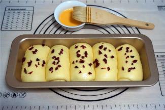 表面刷上一层全蛋液，并撒上剩余的蔓越莓干。