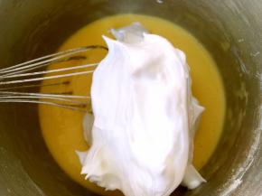 将打发好的蛋白分次加入蛋黄糊中翻拌均匀