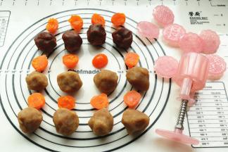 准备好月饼馅料，我这次用了红酒蔓越莓和金装白莲蓉馅两种，把蛋黄一切为二，大约7克左右。馅料和蛋黄一起称重，每个共40克。