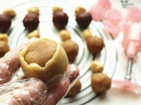 饼皮按扁，包入内陷，一点点推上去，最后完全包裹住馅料。