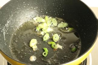 锅里爆香葱末。