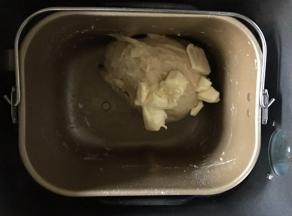 将室温软化过的黄油分两次加入面团中，每加入一次都要揉至面团彻底吸收黄油