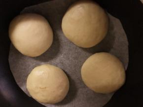 将包好的其中4个乳酪包放入平底锅中（锅内放一张油纸），盖上锅盖再发酵20分钟，剩余的4个乳酪包也放在油纸上盖上保鲜膜室温发酵