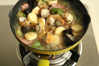 加入火腿片和剪好的日本豆腐。继续煮10秒钟，加入扇贝肉。