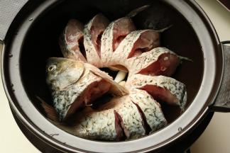 鱼蜷起来放入砂锅。