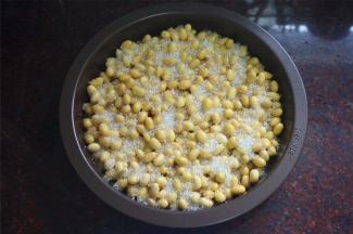 将泡开的黄豆放入容器，然后铺上50克砂糖，无需搅拌。