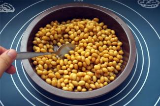 蒸好的豆比较绵软，用勺子稍作翻拌，让豆子全部沾上糖水。