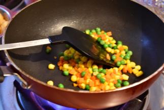 锅内放入食用油翻炒田园豆，再加入适量的水翻炒几下