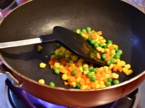 锅内放入食用油翻炒田园豆，再加入适量的水翻炒几下