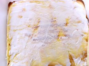 蛋糕卷都凉透后，先在虎皮蛋糕卷上抹一层淡奶油