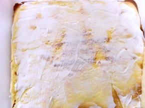 蛋糕卷都凉透后，先在虎皮蛋糕卷上抹一层淡奶油