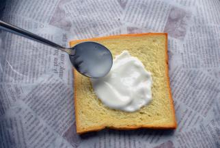 取一片方包片，抹上浓稠酸奶。