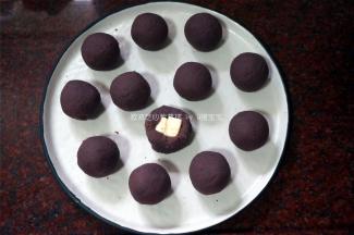 将紫番薯馅包裹奶油芝士方粒，并揉成圆球。
4、