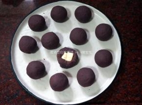 将紫番薯馅包裹奶油芝士方粒，并揉成圆球。
4、